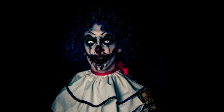 klovne statue Crazy ugly grunge evil clown in town on Halloween making people shock and scared